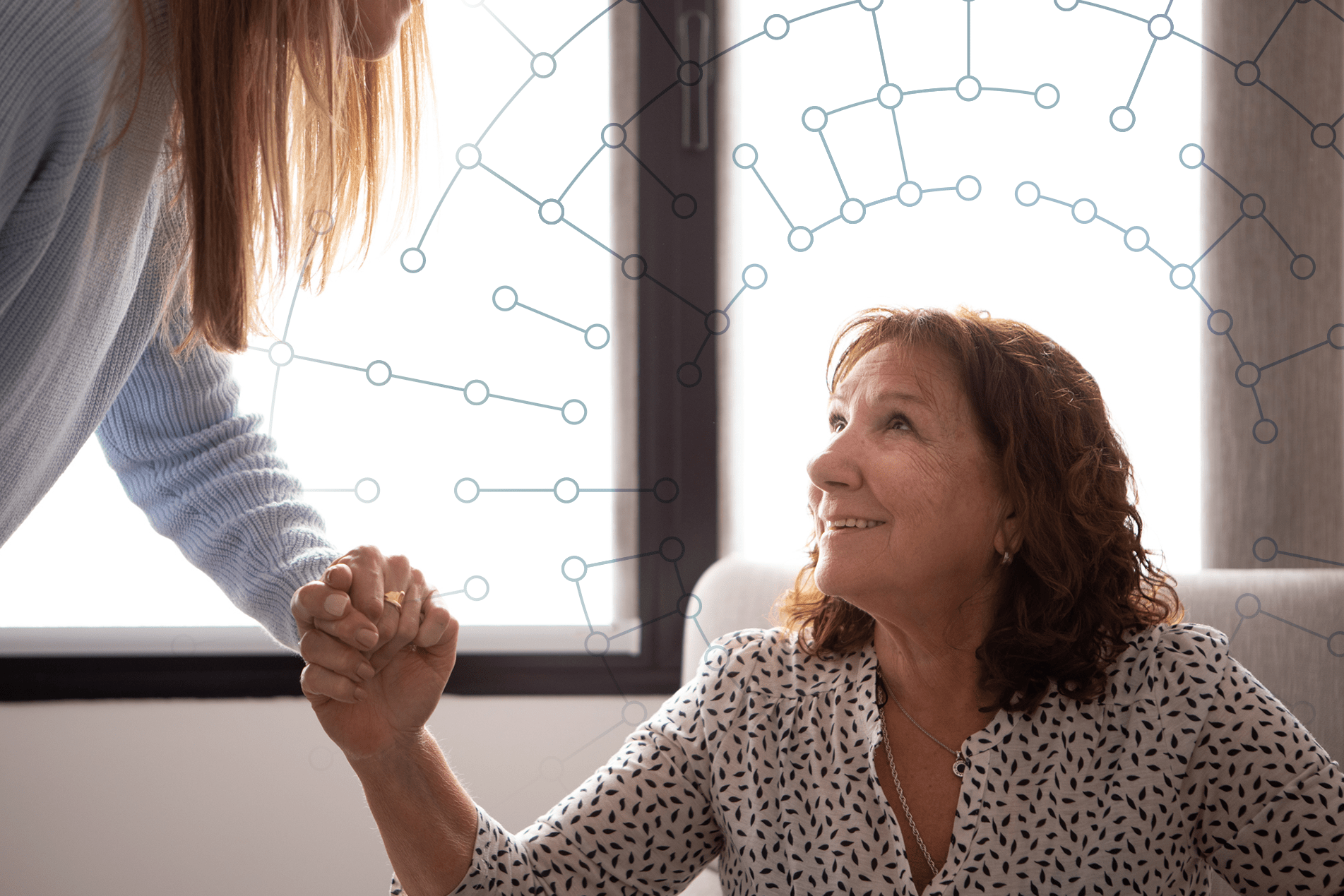 woman helping another woman stand up from a chair