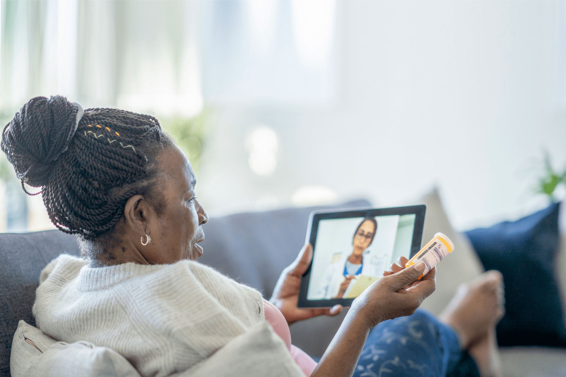 Older adult using a tablet to discuss medication with her doctor