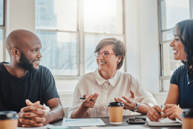 Employees discussing around a table with coffee