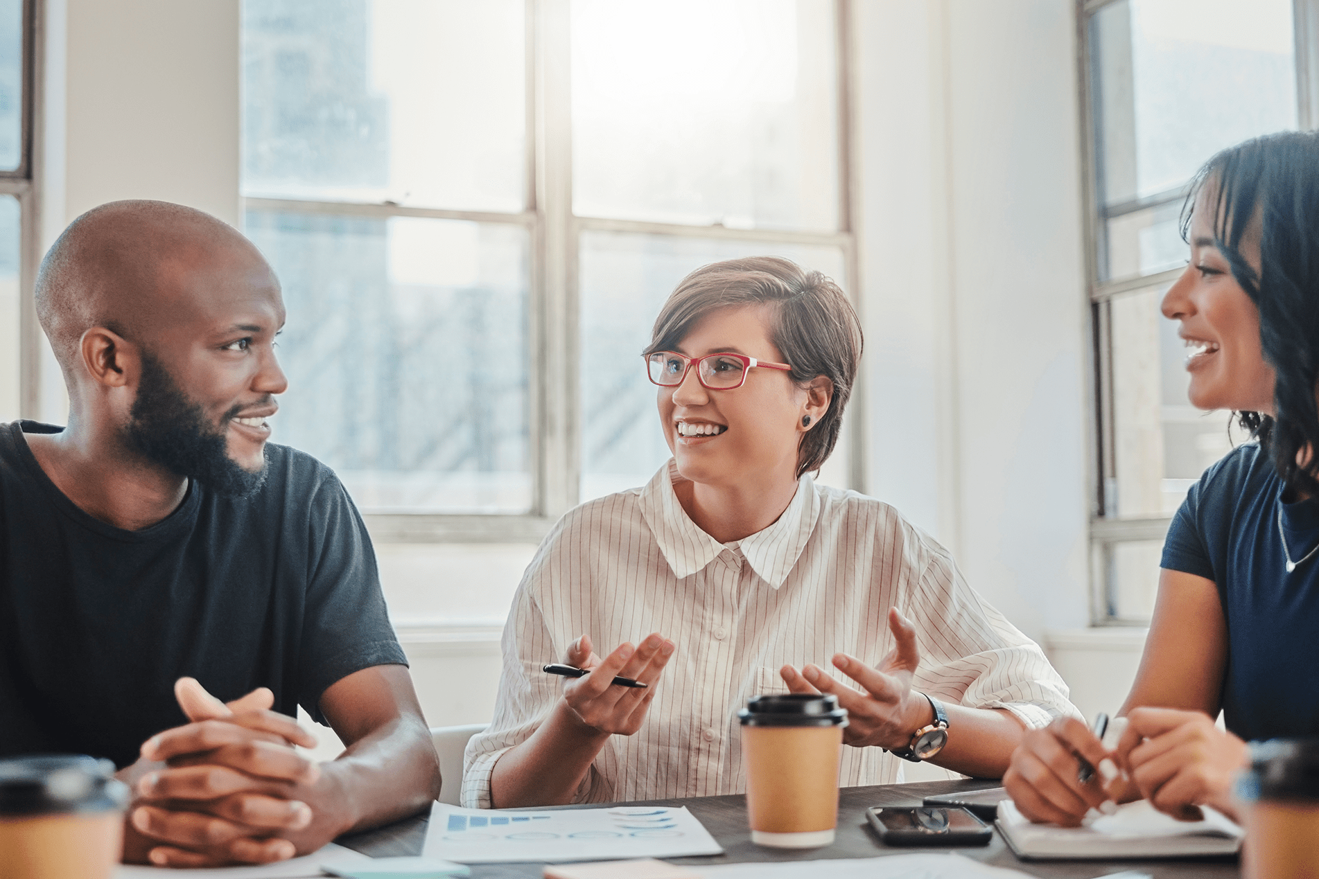 Employees discussing around a table with coffee