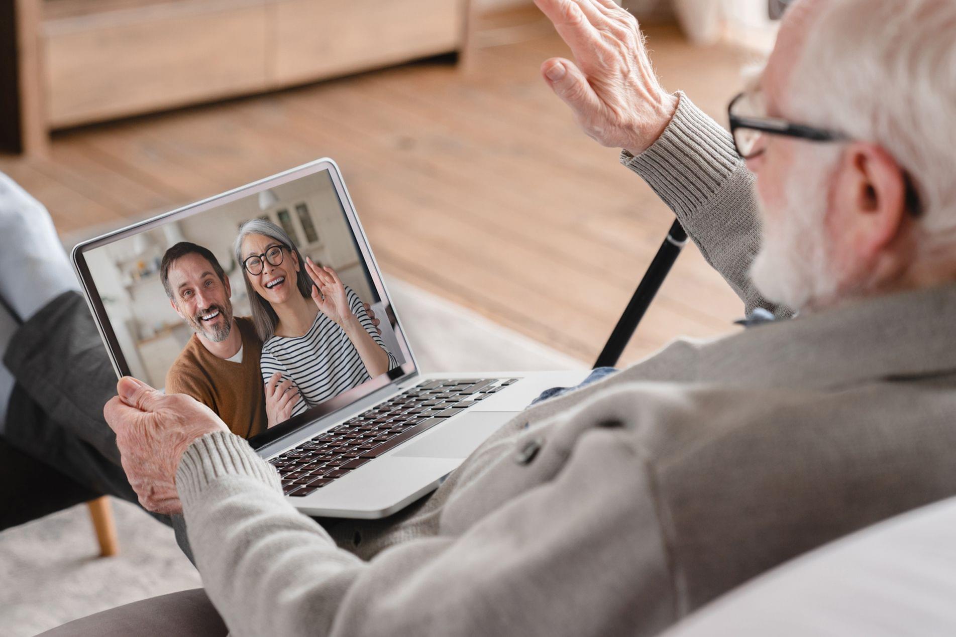 Older adult visiting with friends over online video
