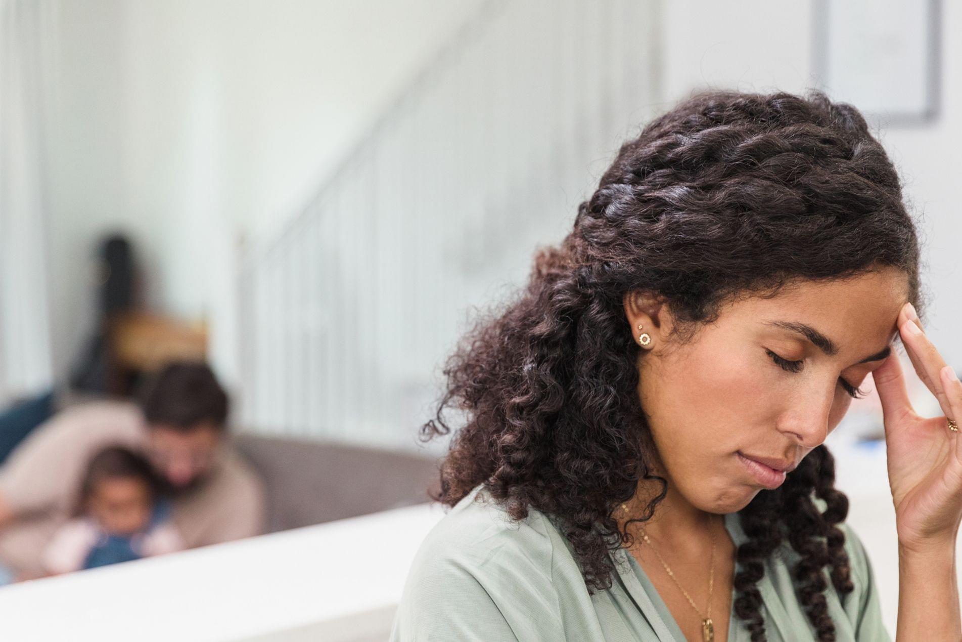 Emotionally drained woman rubs temples