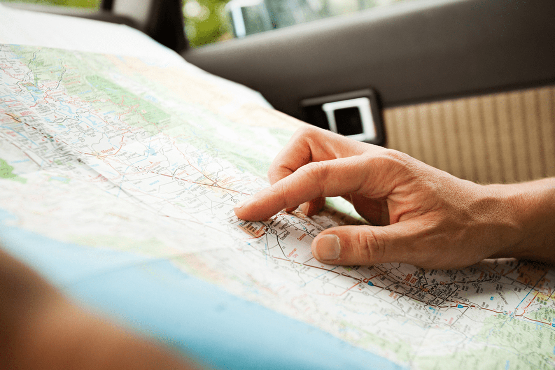 An 8 year old girl with down syndrome reading in the library, sitting next to a therapy dog and trainer, a mature woman in her 50s. The goldendoodle, resting his head on the book in the child's lap, is trained as a reading assistance dog.