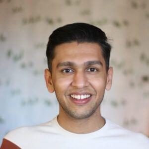 A smiling man with short hair against a careers-themed patterned background.