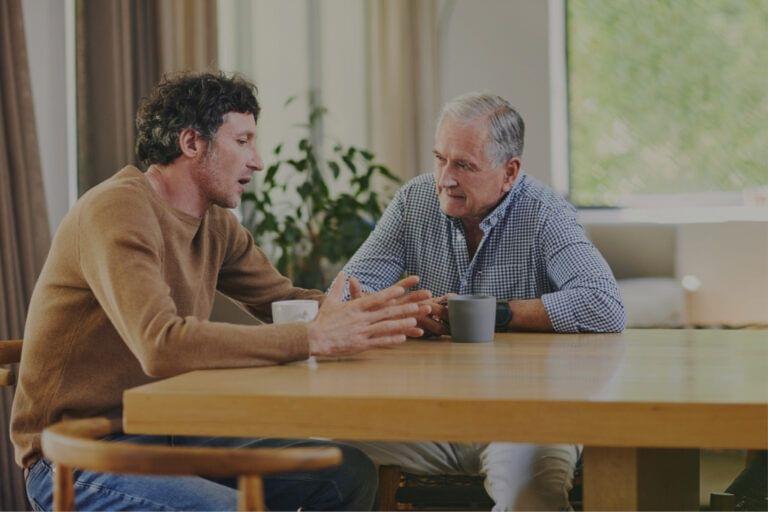 Two caregivers engaged in a conversation at a table.