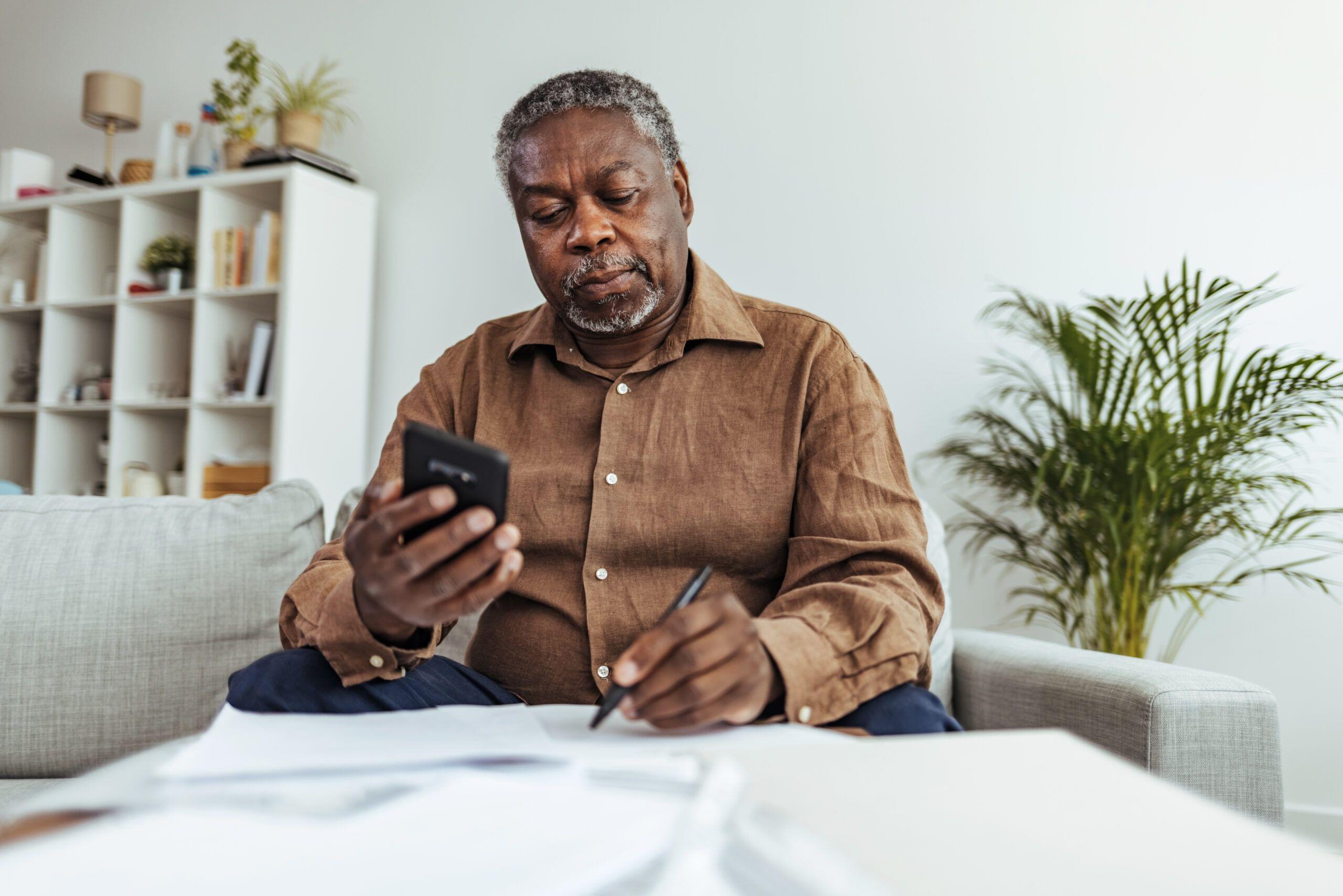 Depressed Senior Adult Man With Stacks of Papers and Envelopes